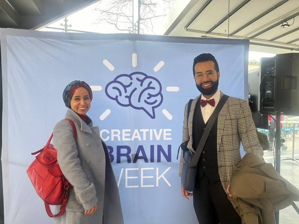 Cross‑disciplinary dialogue — With a fellow delegate at the conference backdrop